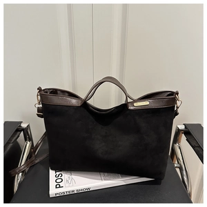 Détail du cabas en daim avec bordures en cuir et finitions en métal doré chic