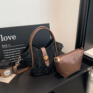 Minimalist black and brown vintage tote bag set on a desk with a matching small pouch