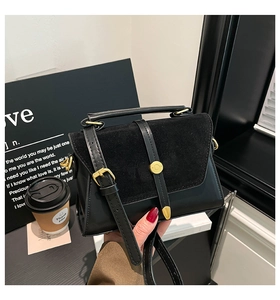 Detailed close-up of black crossbody bag with suede-leather mix and gold buckle