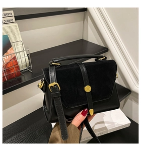 Detail of black crossbody bag with mixed suede and smooth leather textures and gold hardware