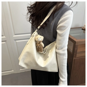 Dettaglio della borsa hobo con texture plissettata e ciondolo a forma di orsetto carino