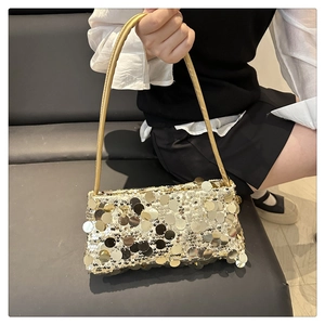 Detailaufnahme großer champagnerfarbener Pailletten auf der Tasche mit Metallic-Textur