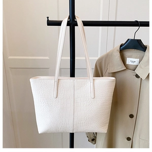 Detail of white crocodile pattern large tote bag with elegant vertical stitching