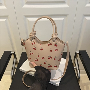 Beige draagtas met kersenprint, ronde handvaten en een slanke verstelbare schouderriem