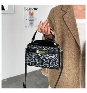 Detailed close-up of leopard print shoulder bag with golden metallic twist-lock fastener
