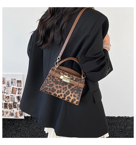 Rear view of a stylish leopard print crossbody bag with brown straps and gold metal buckle