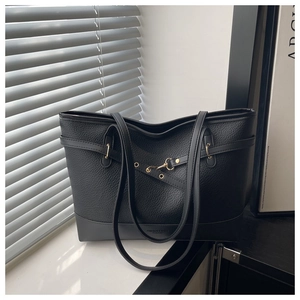 Detail of black pebbled leather tote with FASHION & BAGS lettering and metal buckle