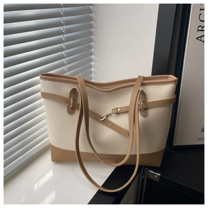 Detail of lychee textured tote bag with contrast stitching and decorative strap buckle