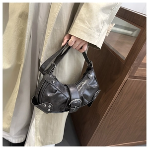 Detail of dark brown leather motorcycle bag with silver rivets and buckle texture
