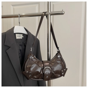 Detail of dark brown vintage crescent bag with silver buckles and stud embellishments