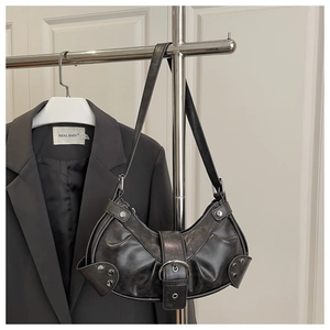 Close-up of dark grey crescent shoulder bag with vintage rivets and buckle details