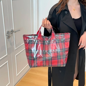 Detail view of waterproof red and green plaid tote bag with PVC outer layer and TOTE BAG text