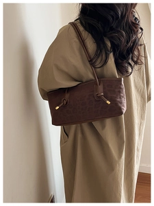 Detail of leopard print shoulder bag featuring suede texture and gold metal strap tips