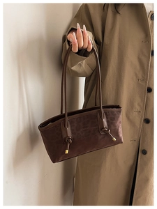 Detail of leopard embossed crossbody bag with knotted handle and gold metal accents