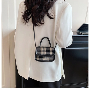 Close-up of a plaid pattern mini crossbody bag styled with a white blazer for a chic look