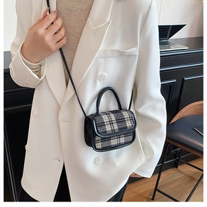 Vue détaillée d'un petit sac à bandoulière à carreaux noir et blanc sur un mannequin