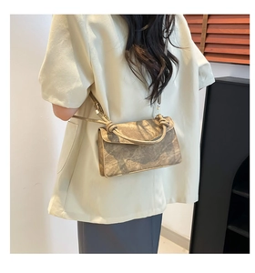 Detail view of retro textured brown crossbody bag with knotted handle on a model