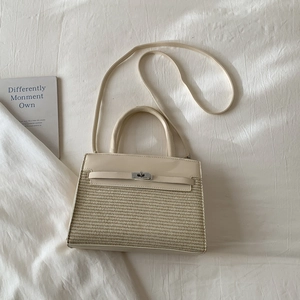 Detail of cream woven crossbody bag with metallic twist-lock and elegant top handle