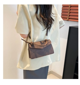 Rear view of model wearing a brown vintage crossbody bag with knotted handle detail