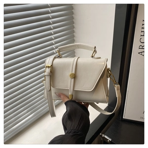 Detailopname van witte PU-lederen flap tas met gouden ronde metalen draaisluiting