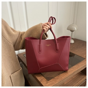 Large burgundy tote bag shown in a professional setting with gold lettering details
