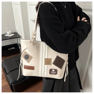 Detalle del bolso tote blanco roto con parches de moda y cordón lateral ajustable