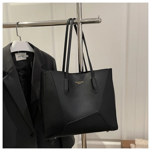 Detail of black faux leather tote bag with gold lettering and geometric stitching