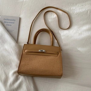Detail of camel leather patchwork bag with woven texture and silver twist lock