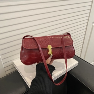 Chic dark red faux crocodile baguette bag with a stylish gold clasp and slim strap