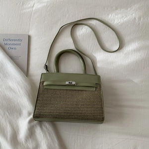 Detail of light green patchwork woven handbag with leather texture and metal buckle