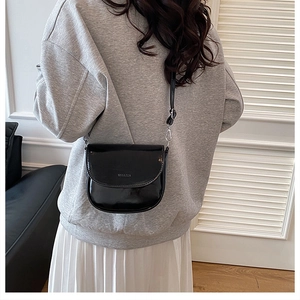 Borsa a tracolla minimalista in pelle nera indossata con un outfit casual moderno