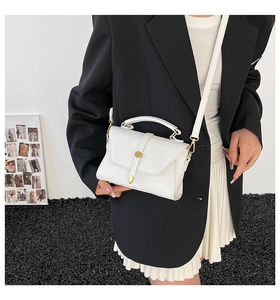 Detail of white litchi pattern leather bag with gold buckle and adjustable strap