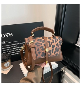 Detailed view of the leopard print flap and golden metal clasp on the brown leather bag