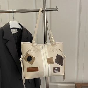 Large cream tote bag with stylish vertical stripes and vintage fashion patches on hanger