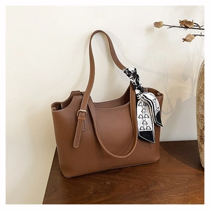 Dettaglio borsa tote marrone a grana litchi con elegante foulard in seta decorativo
