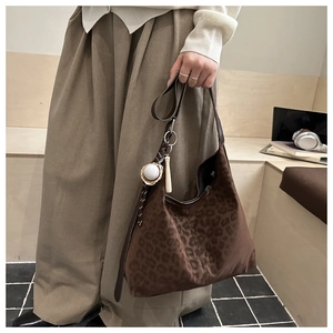 Detail of leopard print hobo bag in faux suede with a sporty baseball bat charm