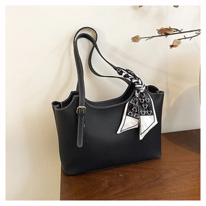 Dettaglio borsa tote nera in pelle martellata con cuciture a contrasto e foulard decorativo