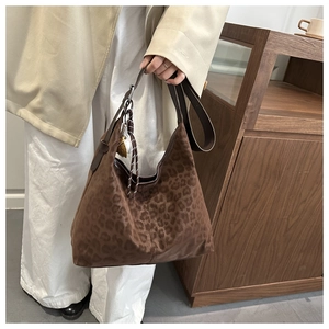Detail view of large brown leopard print tote bag with soft suede texture and leather strap