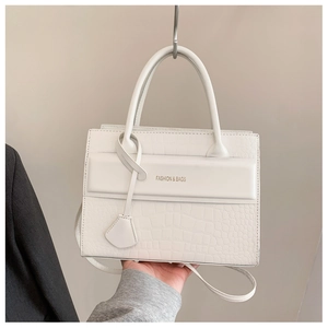 Gros plan du sac cabas blanc avec texture crocodile et bandoulière réglable