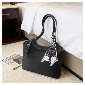 Detailed texture of black lychee grain leather tote bag with decorative silk scarf