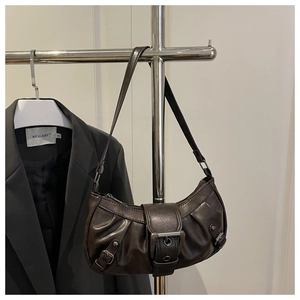 Detail of dark brown leather shoulder bag featuring vintage metal buckle and pleated texture