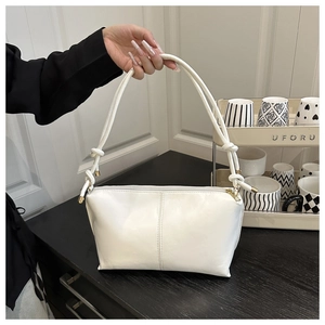 Détail du sac minimaliste blanc avec bandoulière nouée et éléments en métal doré