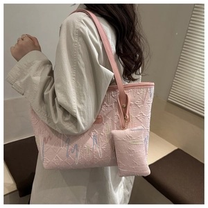 Detail of pink tote bag with wavy embroidery and letter E embossing for women