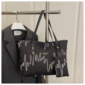 Detail of black tote bag with wave embroidery and attached small zip coin pouch