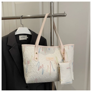 Detail of white textured tote bag with colorful embroidery and matching mini pouch bag
