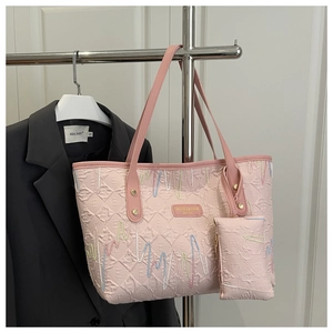 Detail of pink embossed tote bag set with geometric texture and small coin purse attachment