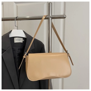 Detail of minimalist beige underarm bag with wavy bottom and metallic strap buckle