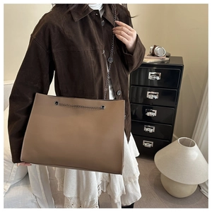 Chic coffee brown tote bag with pebble leather texture and metal chain strap detail