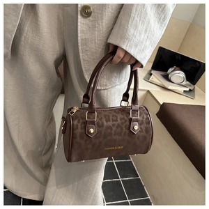 Detail of leopard print boston bag with gold hardware and fashion lettering