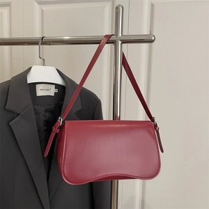 Retro red faux leather underarm bag with curved bottom design on a silver hanger
